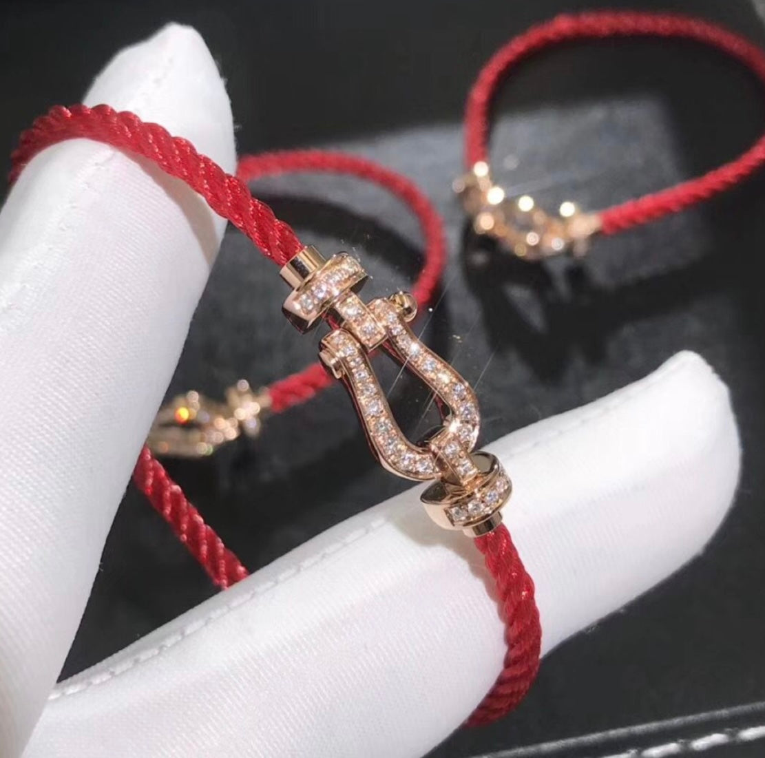 צמיד יוקרתי עם רצועת חבל בגוון אדום ואבזם בגוון זהב ורוד משובץ זירקונים