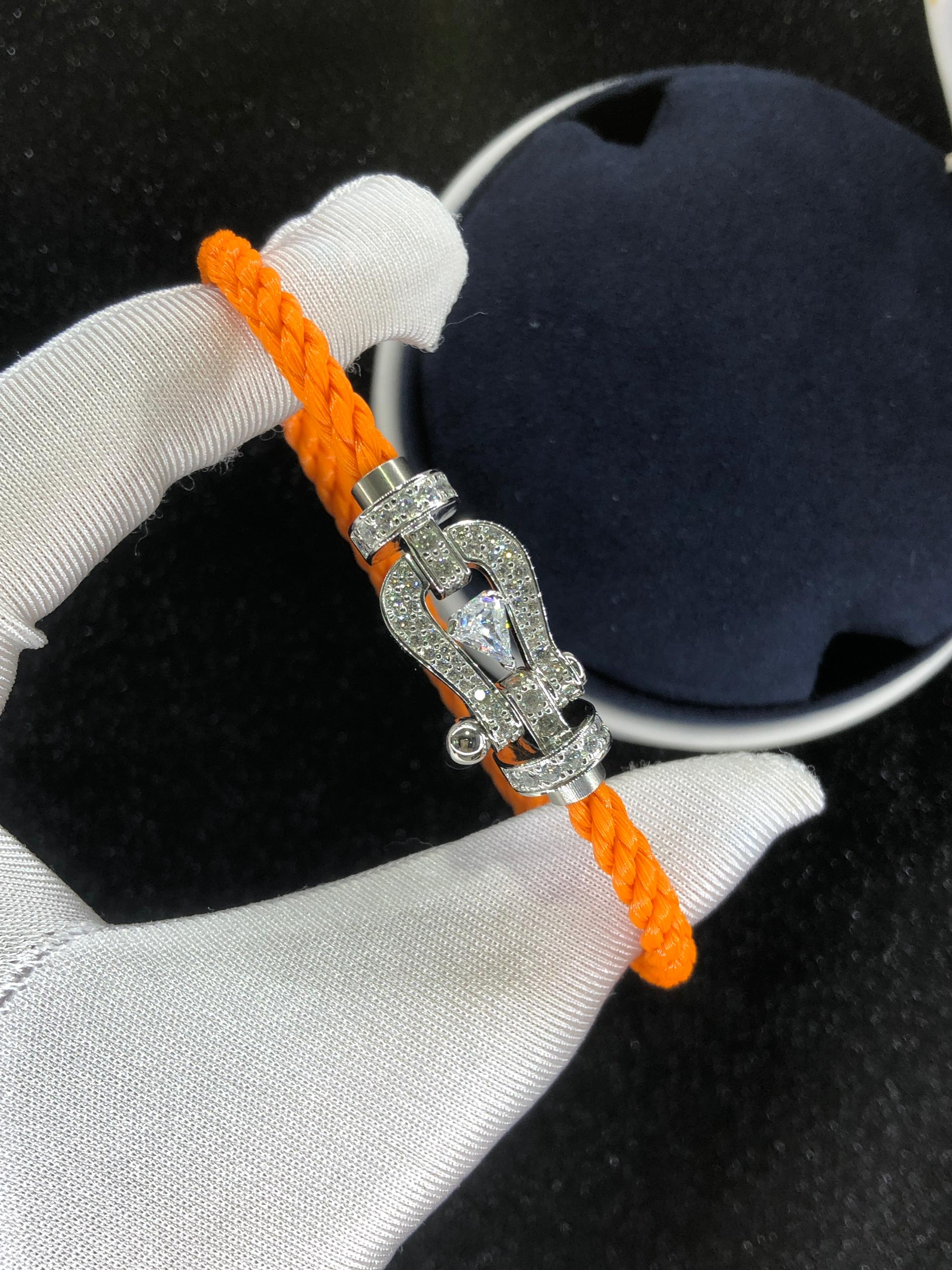 Bracelet luxueux avec une sangle en corde noire et une boucle couleur or rose sertie de zircons, avec une pierre centrale de 0,5 carat